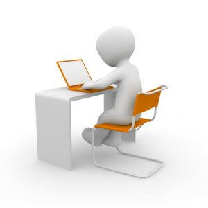 non-descripte figuur aan een bureau met een laptop