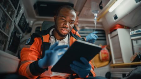 Black EMS Professional Paramedic Using Tablet Computer