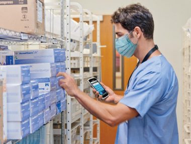 medical stockroom with technician holding a scanner